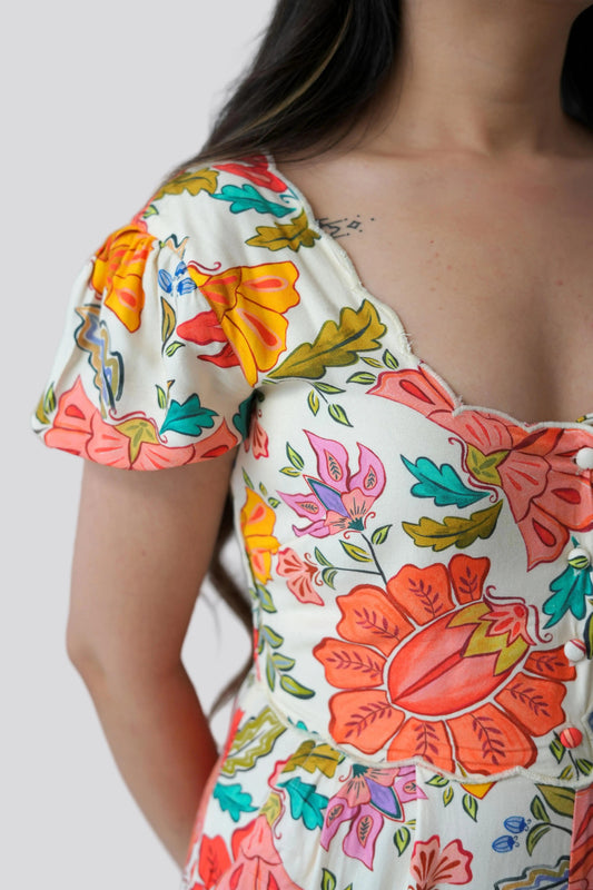 Woman wearing a colorful floral dress with a plain background