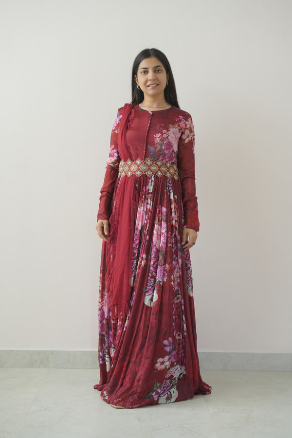 Woman wearing a red floral dress against a white background