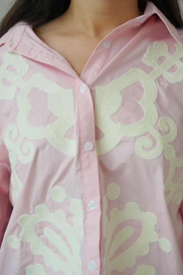 Close-up of a pink garment with decorative white patterns