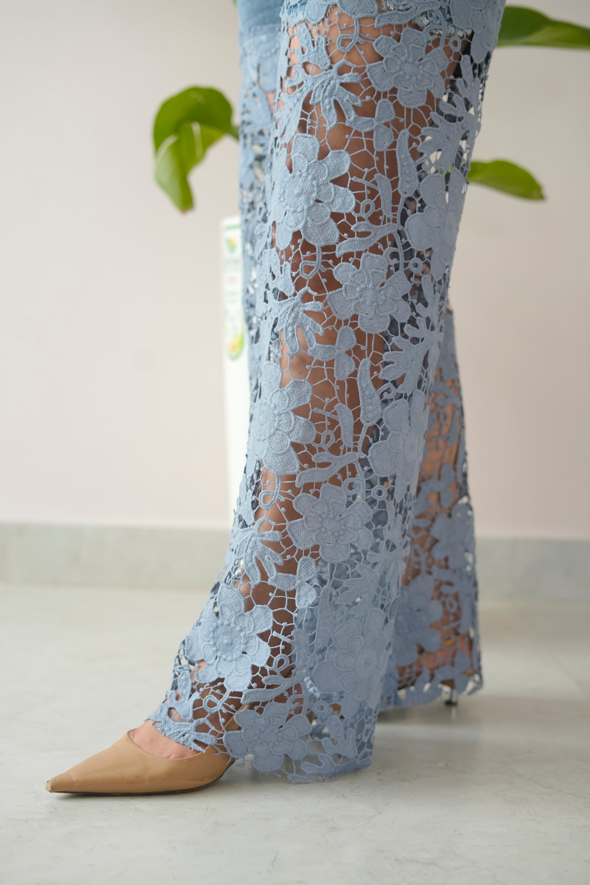 Light blue lace pants worn by a person on a light background
