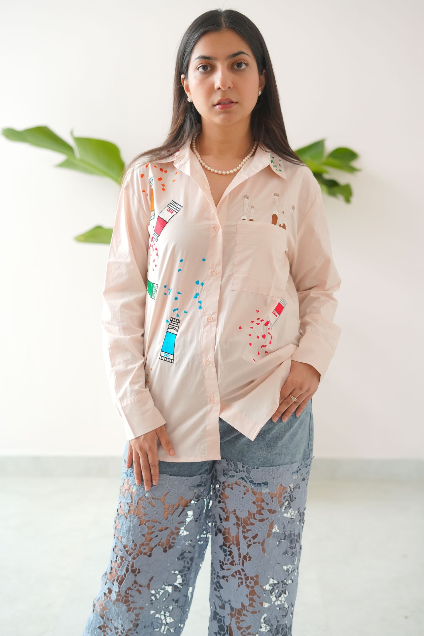 Woman wearing a light-colored outfit with colorful patterns on a white background