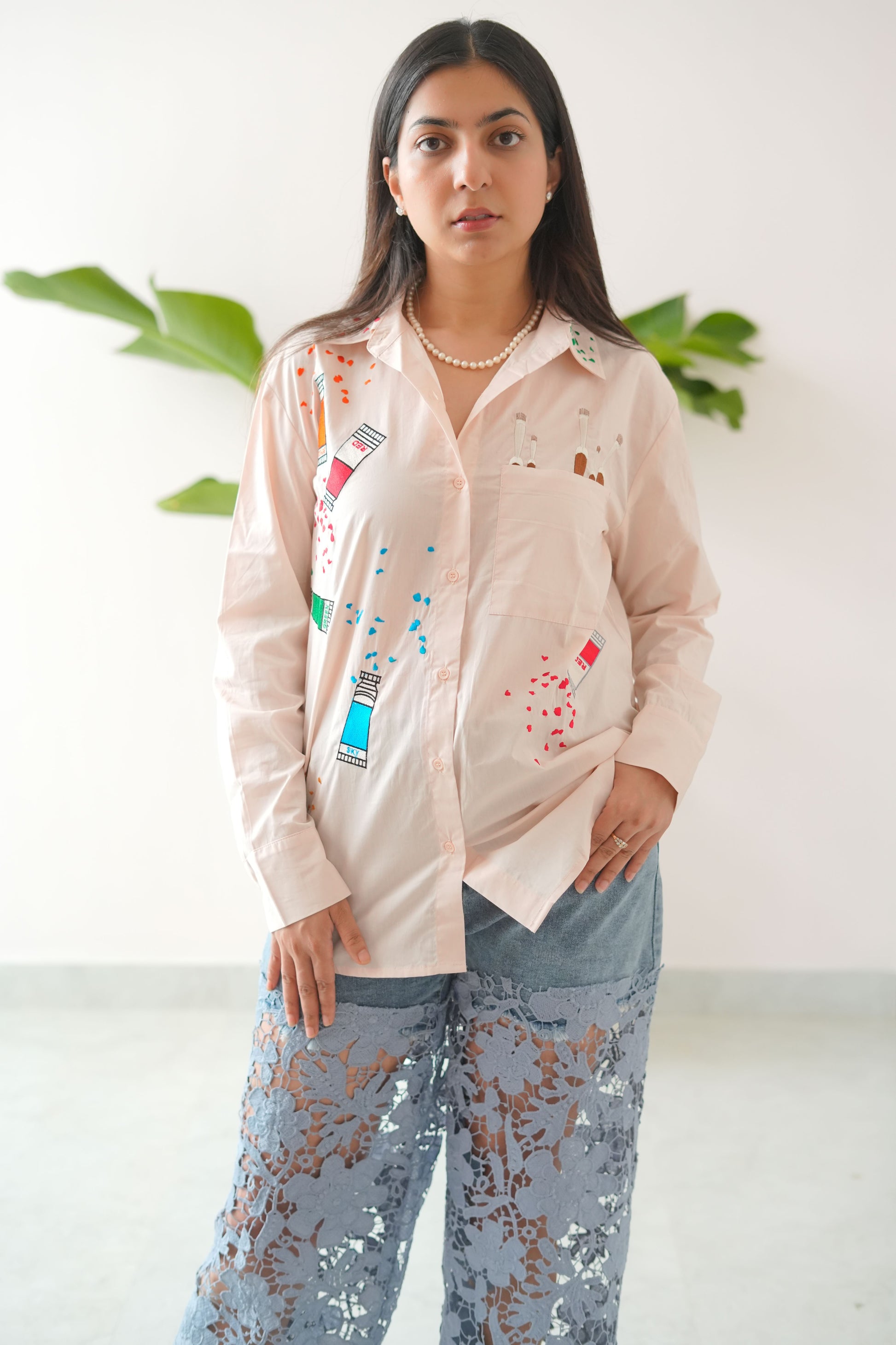 Woman wearing a light-colored outfit with colorful patterns on a white background