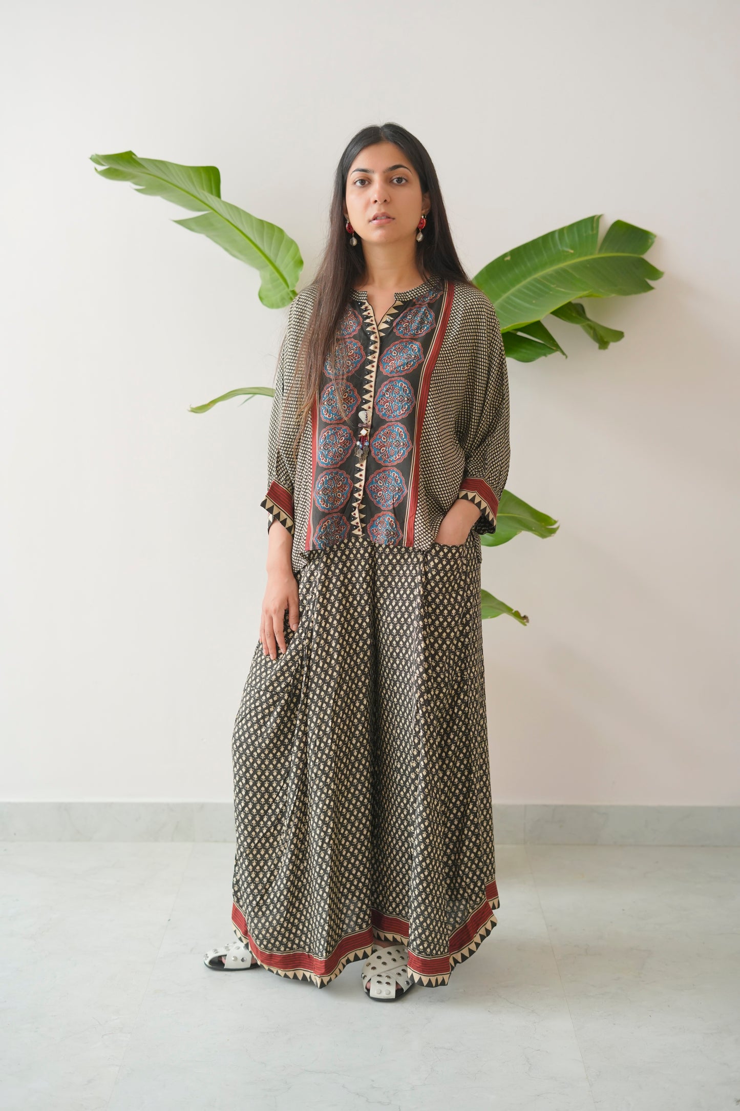 Woman wearing a patterned outfit with a plain background