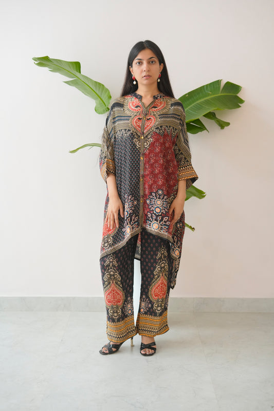 Woman wearing a patterned outfit with large green leaves in the background