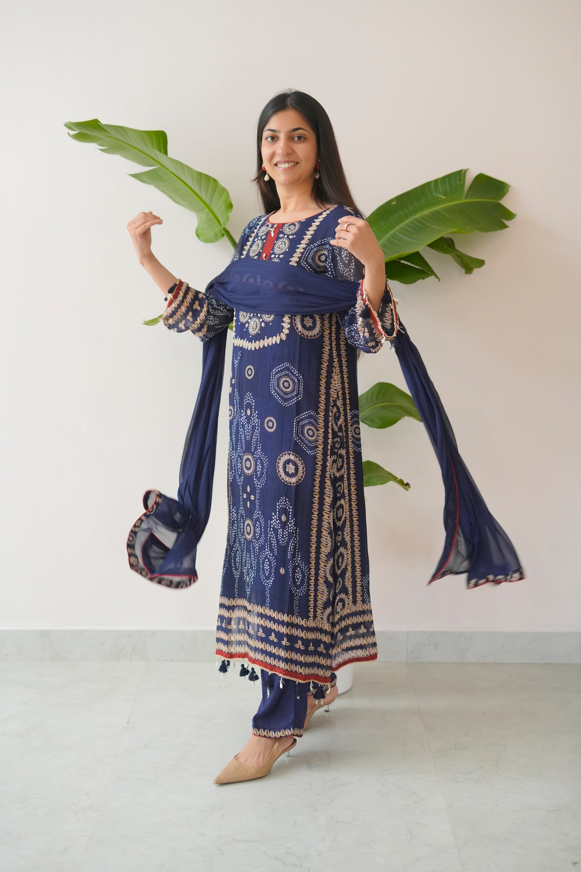 Woman wearing a blue patterned outfit with a white background