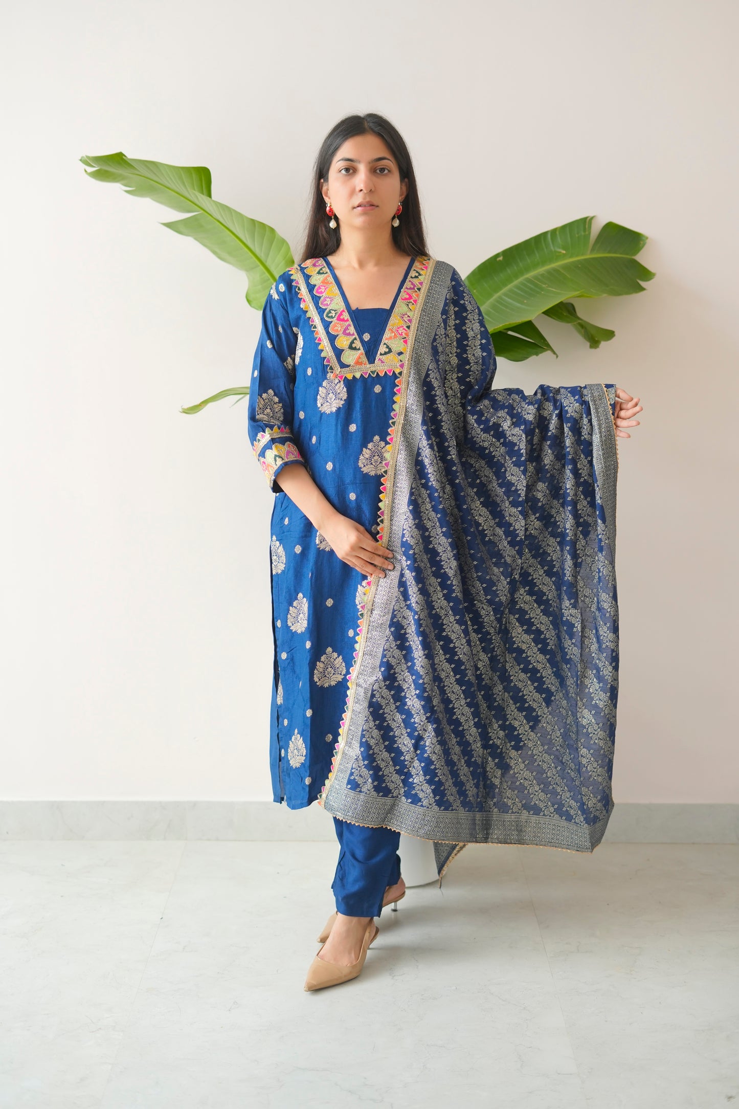 Woman holding a blue patterned scarf against a white background