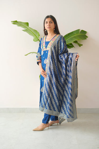 Woman holding a blue and white patterned scarf against a white background
