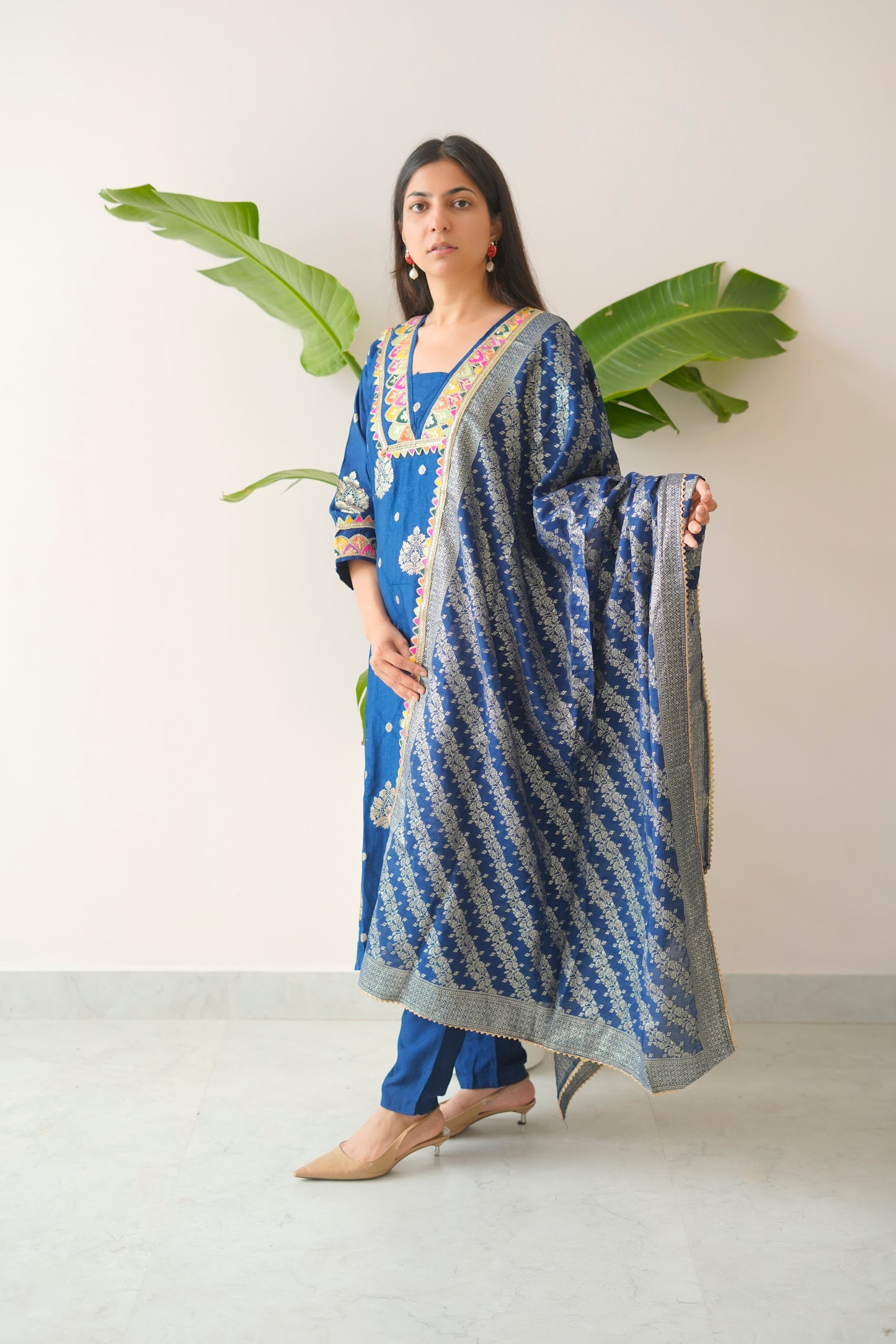 Woman holding a blue and white patterned dupatta against a white background