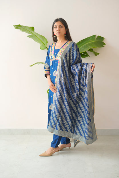 Woman holding a blue and white patterned dupatta against a white background