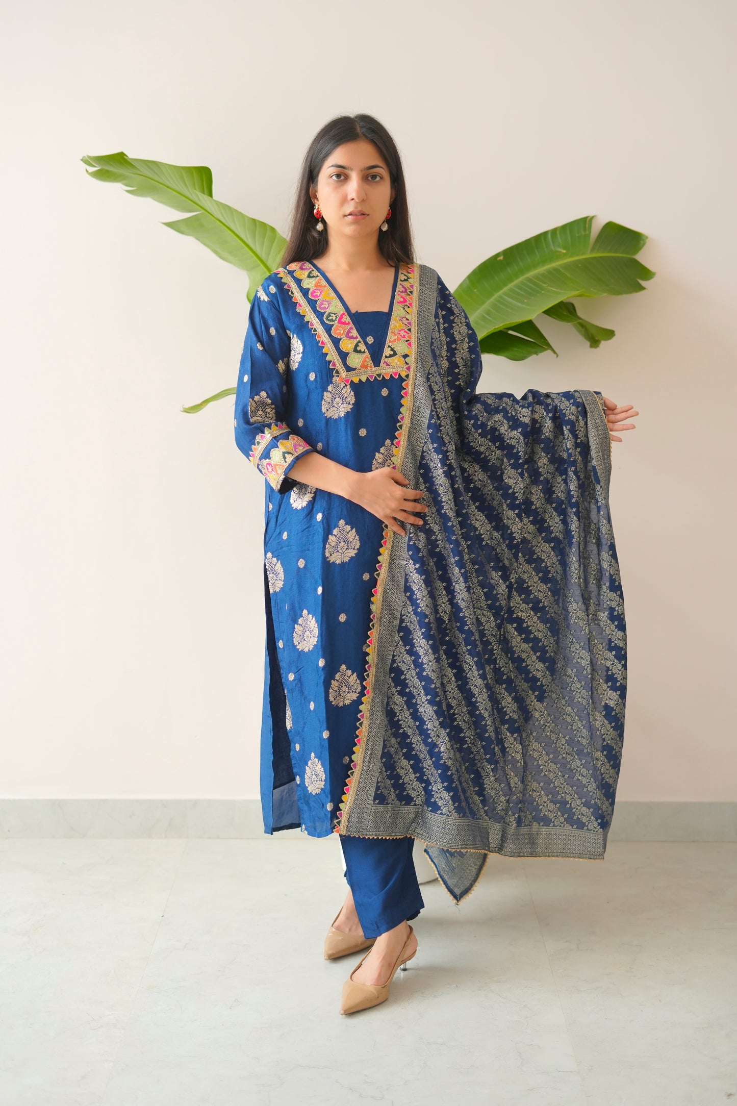 Woman holding a blue and patterned dupatta against a white background