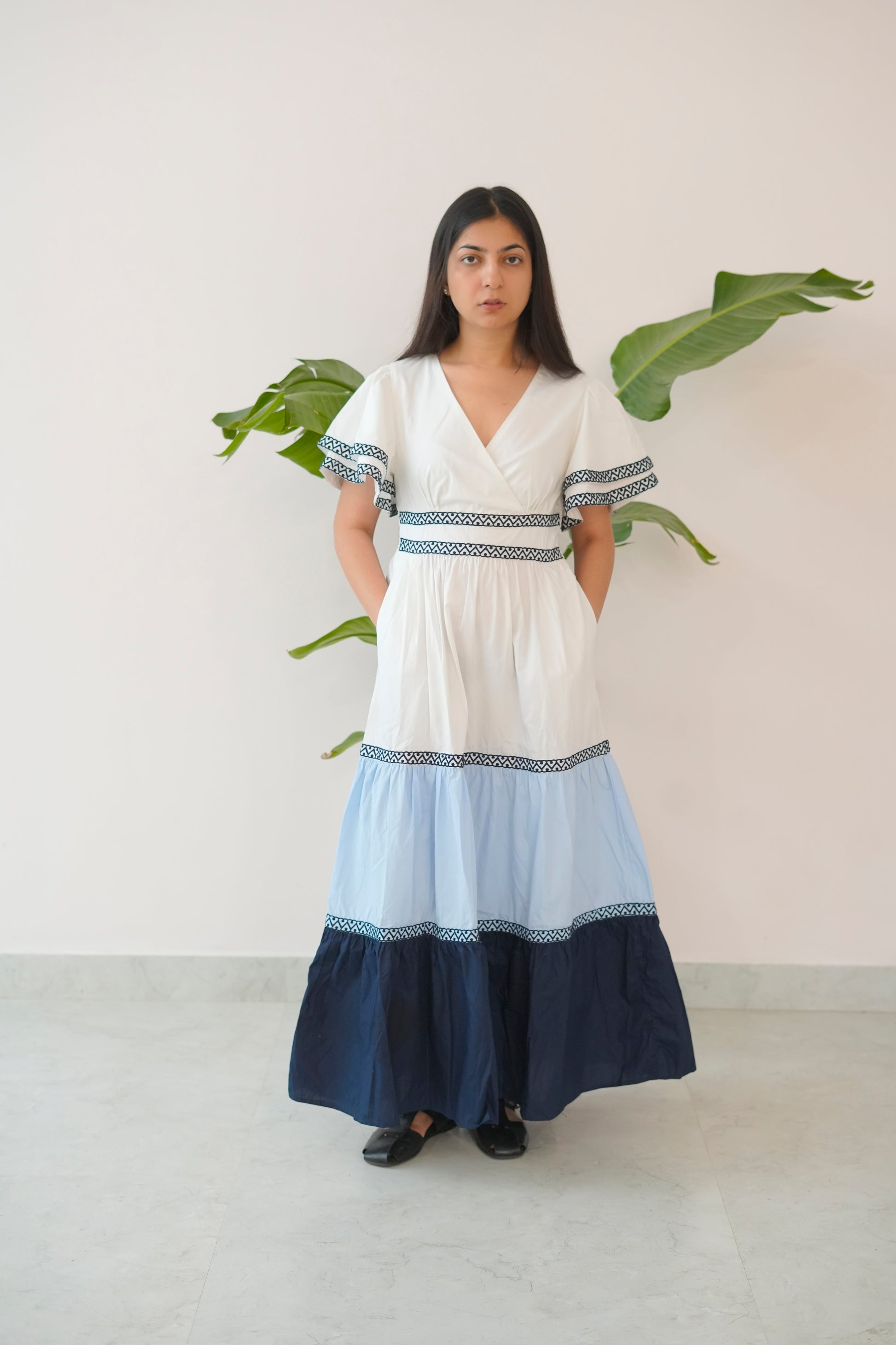 Woman wearing a white and blue dress with a plain background