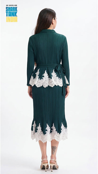Woman wearing a dark green dress with white lace details on a white background