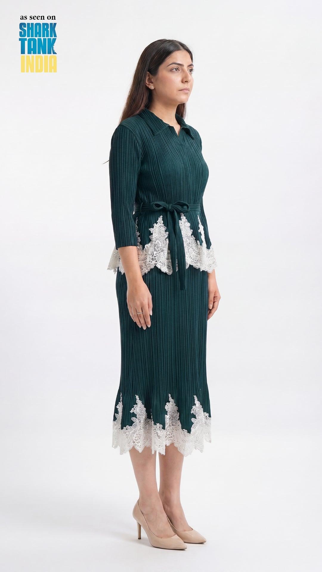 Woman wearing a dark green dress with lace details on a white background, featuring Shark Tank branding.