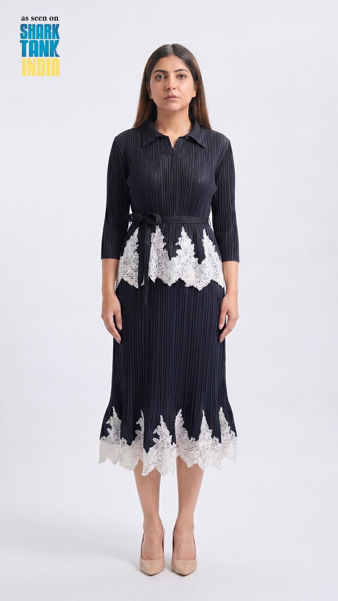Woman wearing a black dress with white lace details on a white background
