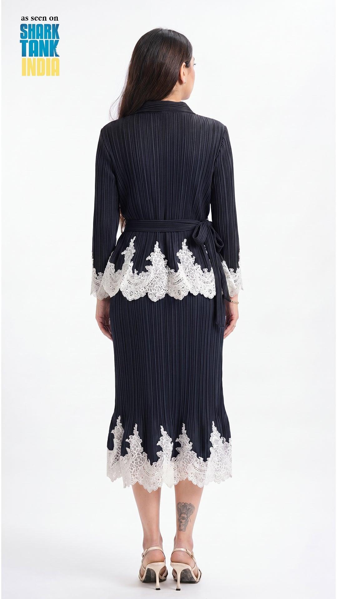 Woman wearing a navy dress with white lace details on a white background
