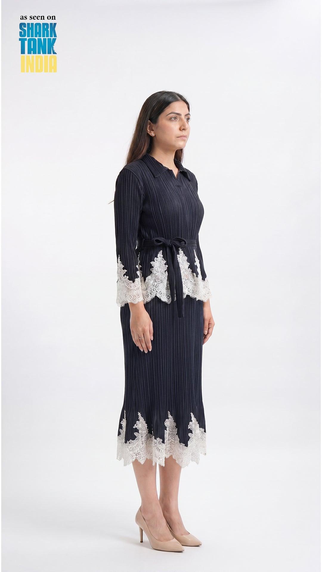 Woman wearing a navy dress with white lace details on a white background