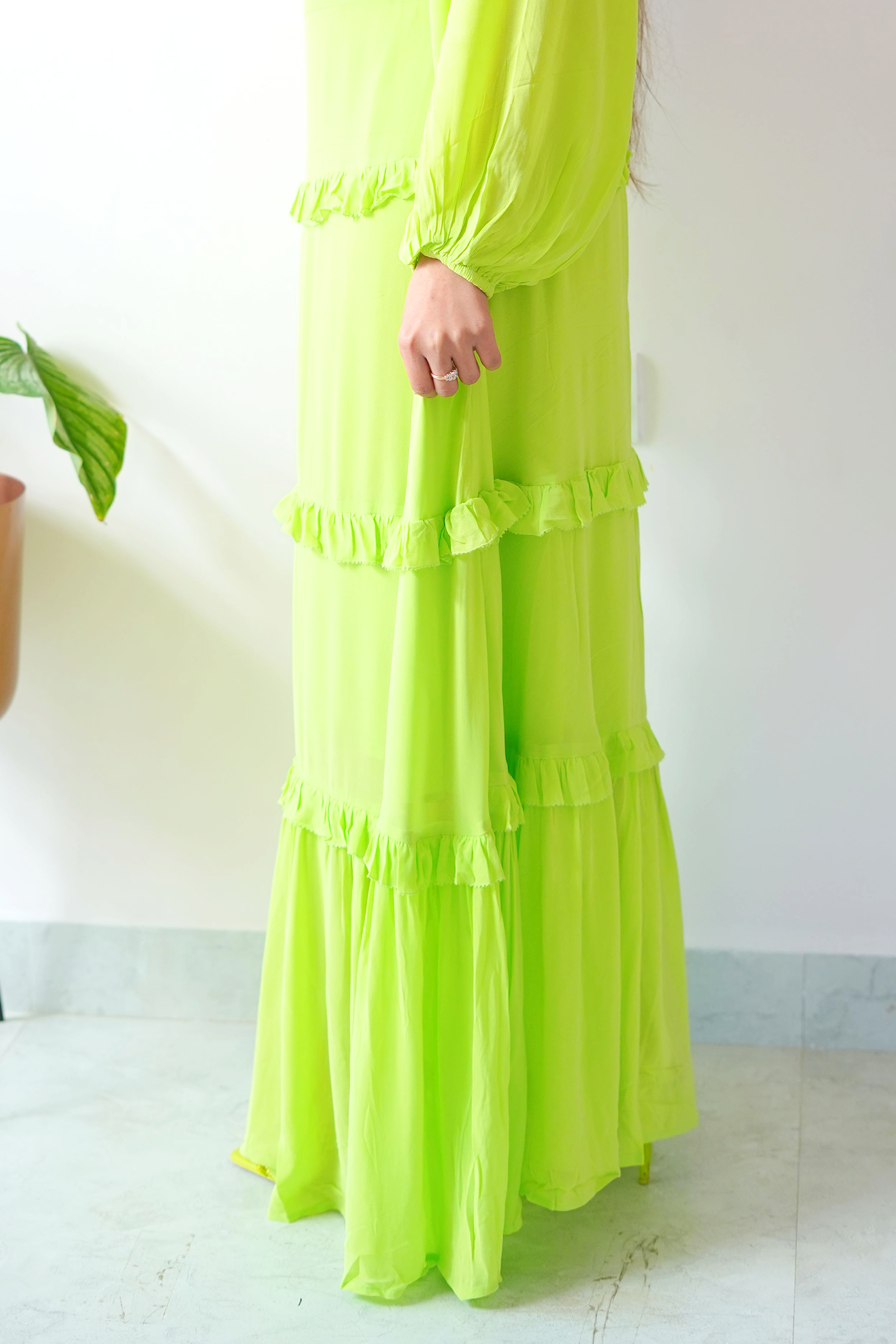 Green dress with ruffled layers on a white background