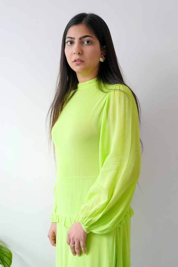 Woman wearing a bright green dress against a plain background