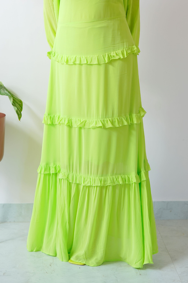 Neon green dress with ruffled layers on a white background
