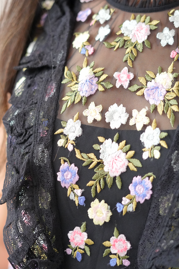 Black lace garment with colorful floral embroidery