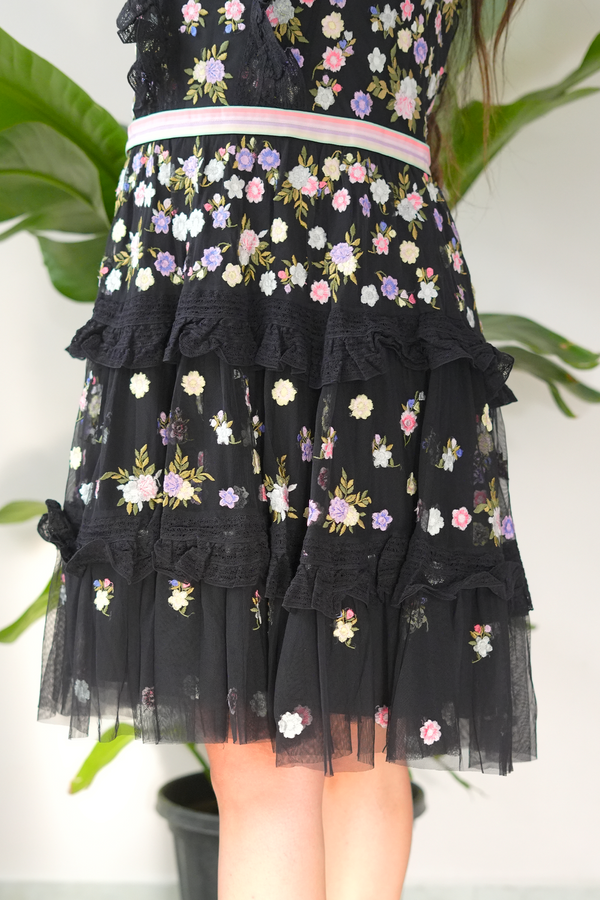 Black floral embroidered dress with ruffled layers on a white background