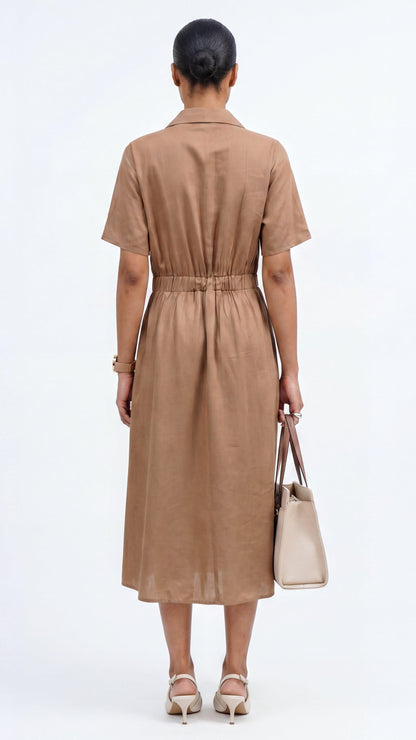 Woman wearing a brown dress holding a beige handbag on a white background