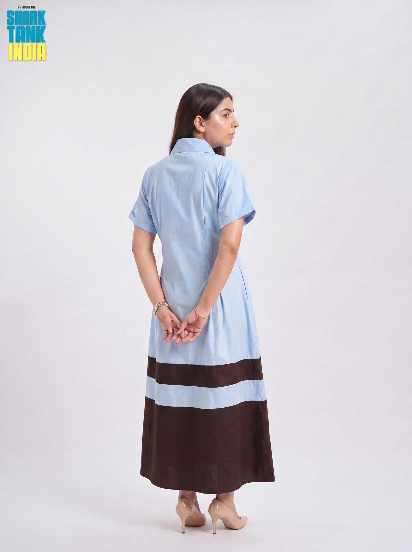 Woman wearing a light blue and brown dress on a white background