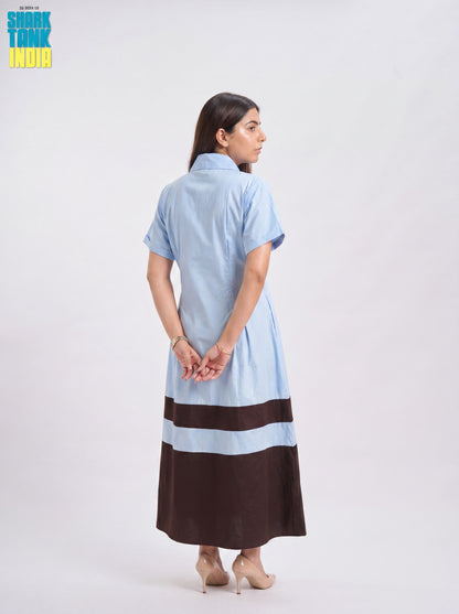 Woman wearing a light blue and brown dress on a white background
