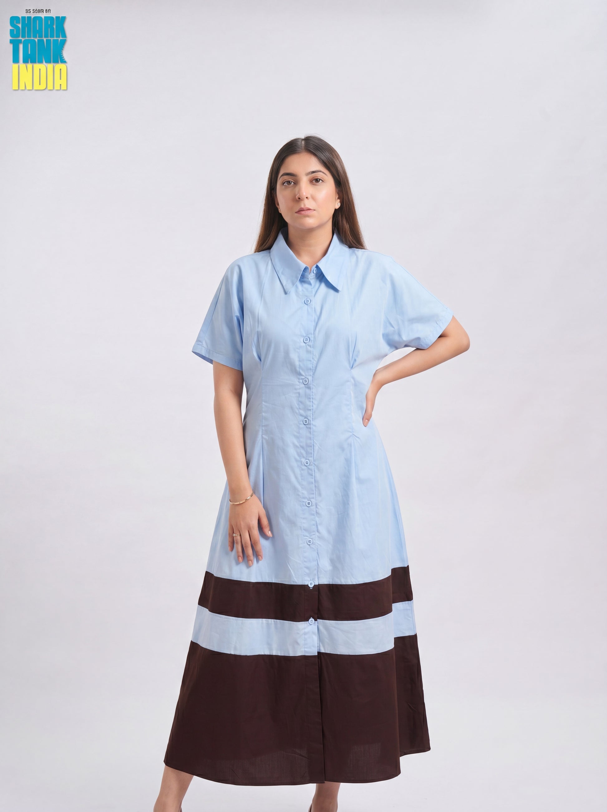 Woman wearing a light blue and brown dress on a white background