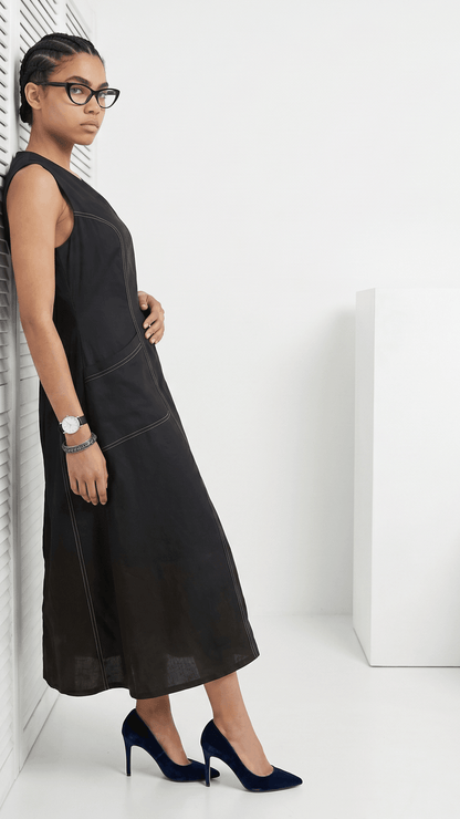 Woman wearing a black dress and high heels against a white background