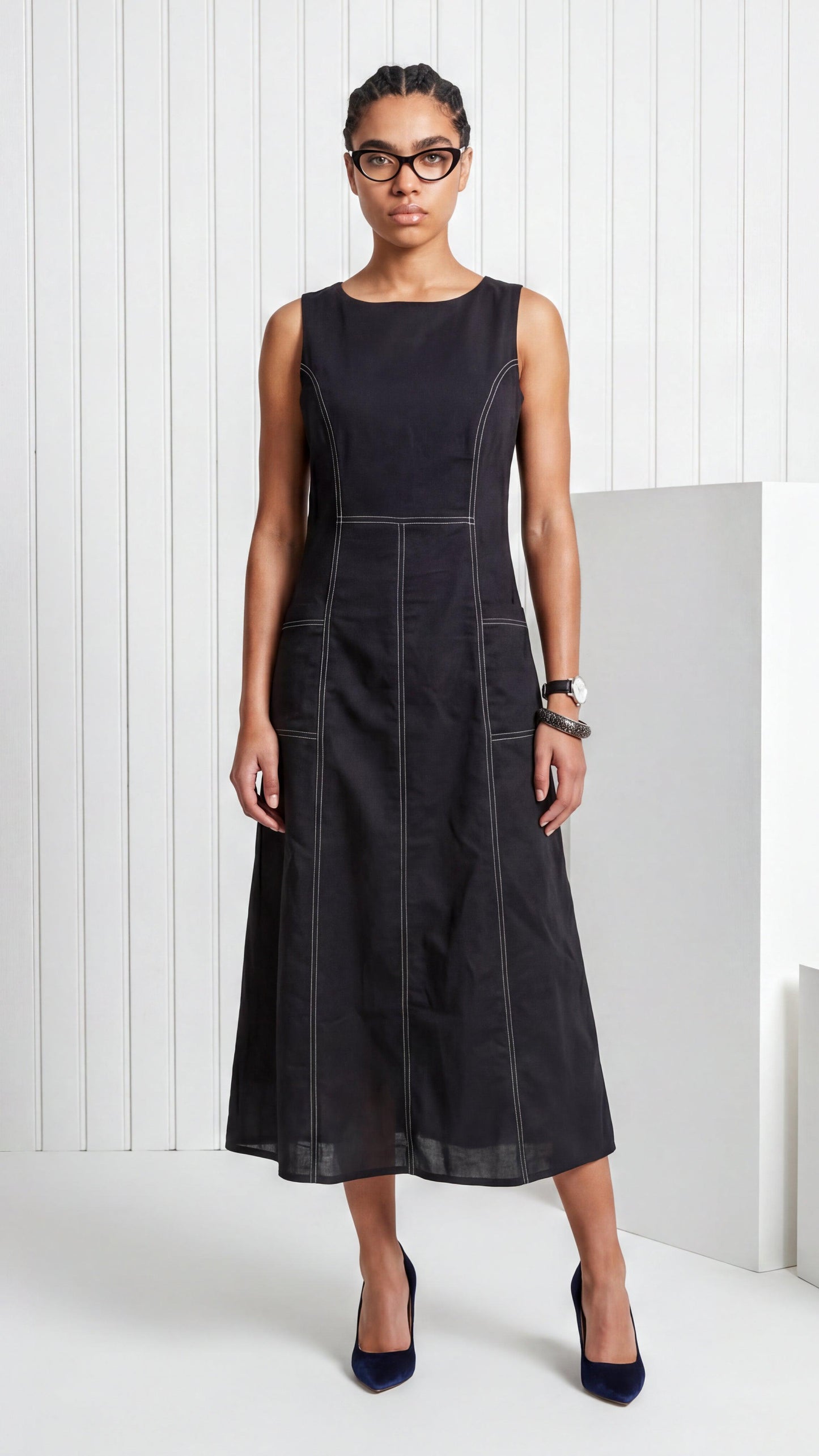 Woman wearing a black sleeveless dress against a white background
