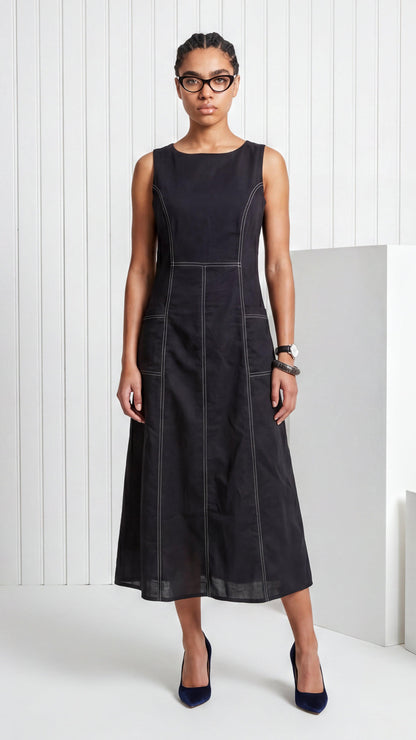 Woman wearing a black sleeveless dress against a white background