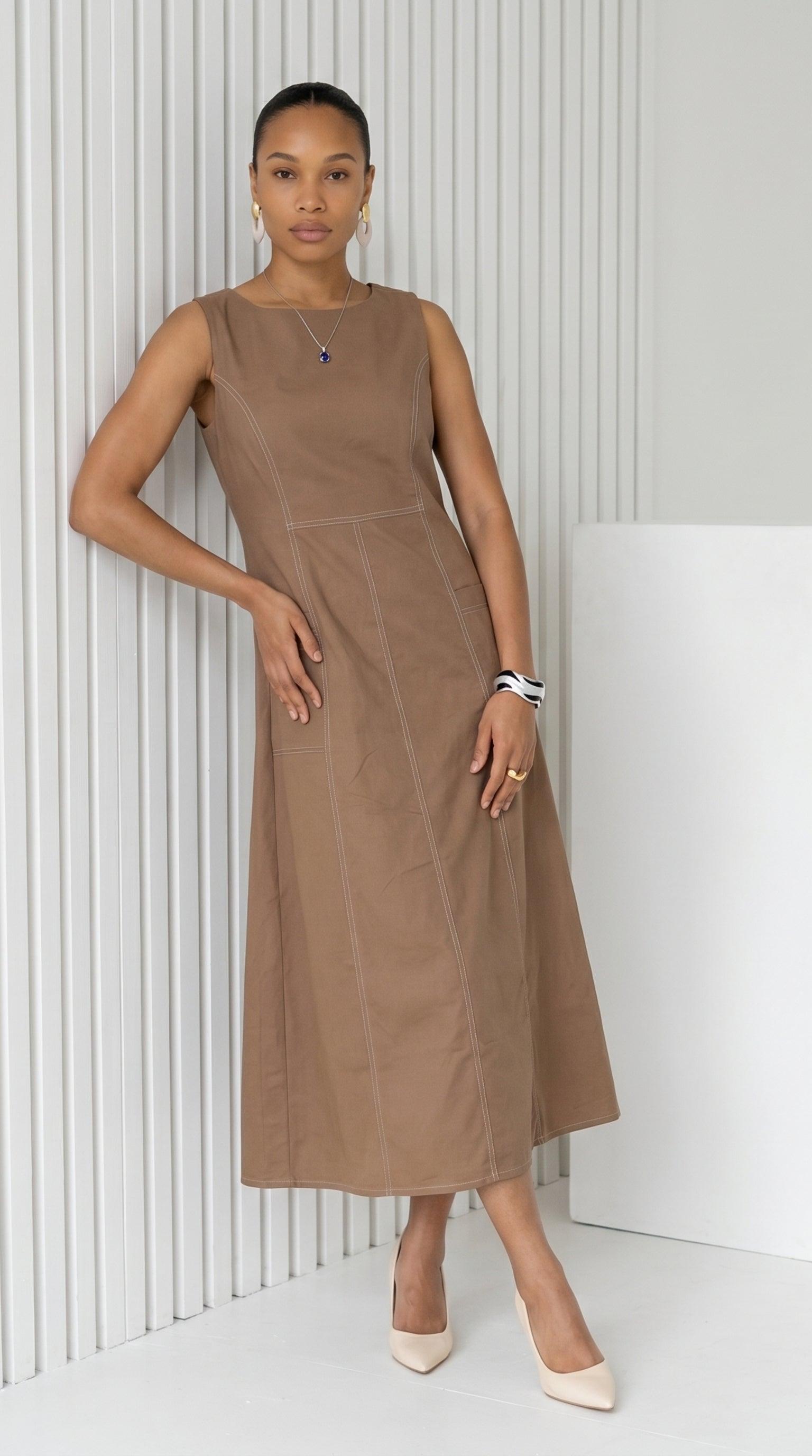 Woman wearing a brown dress against a white background
