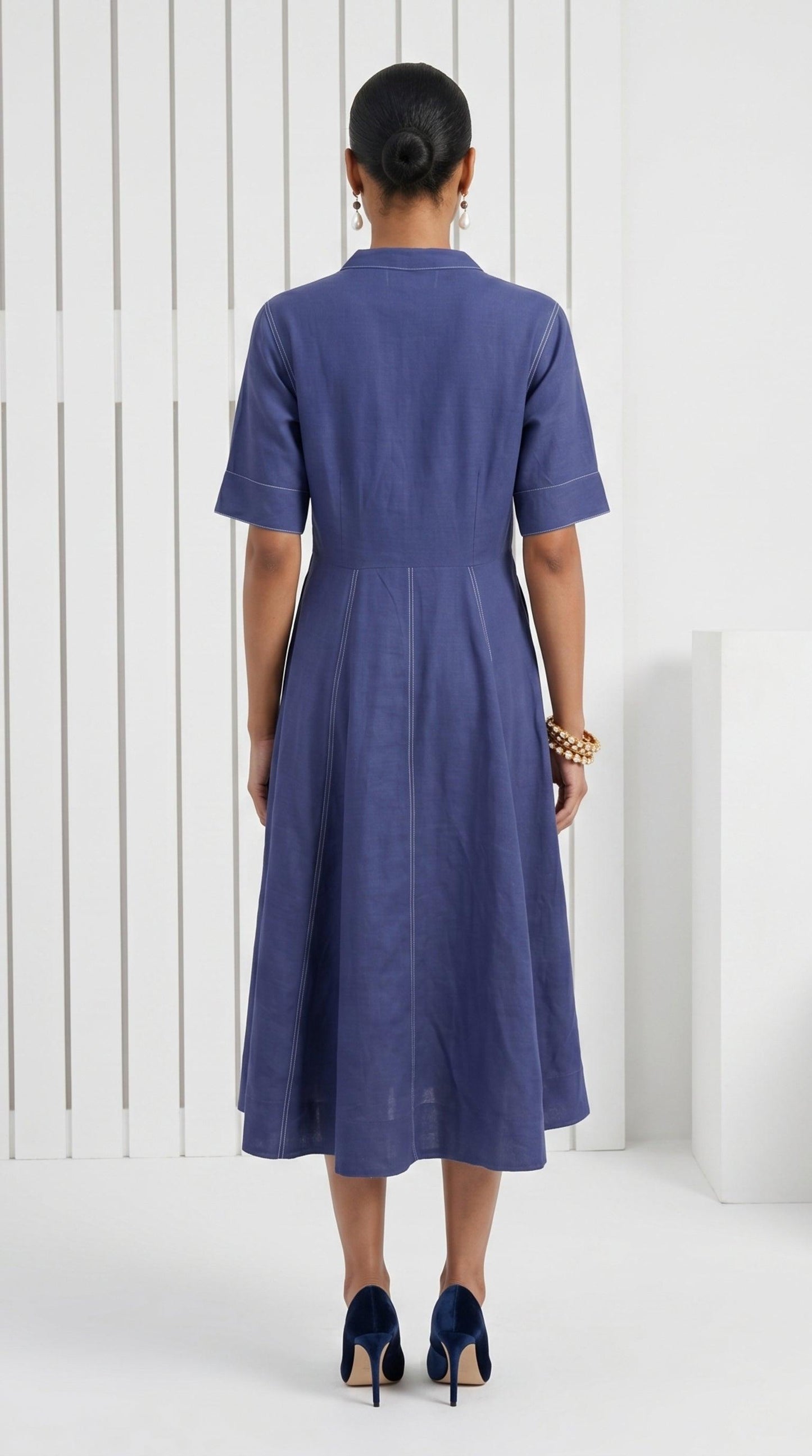 Woman wearing a blue dress standing against a white background