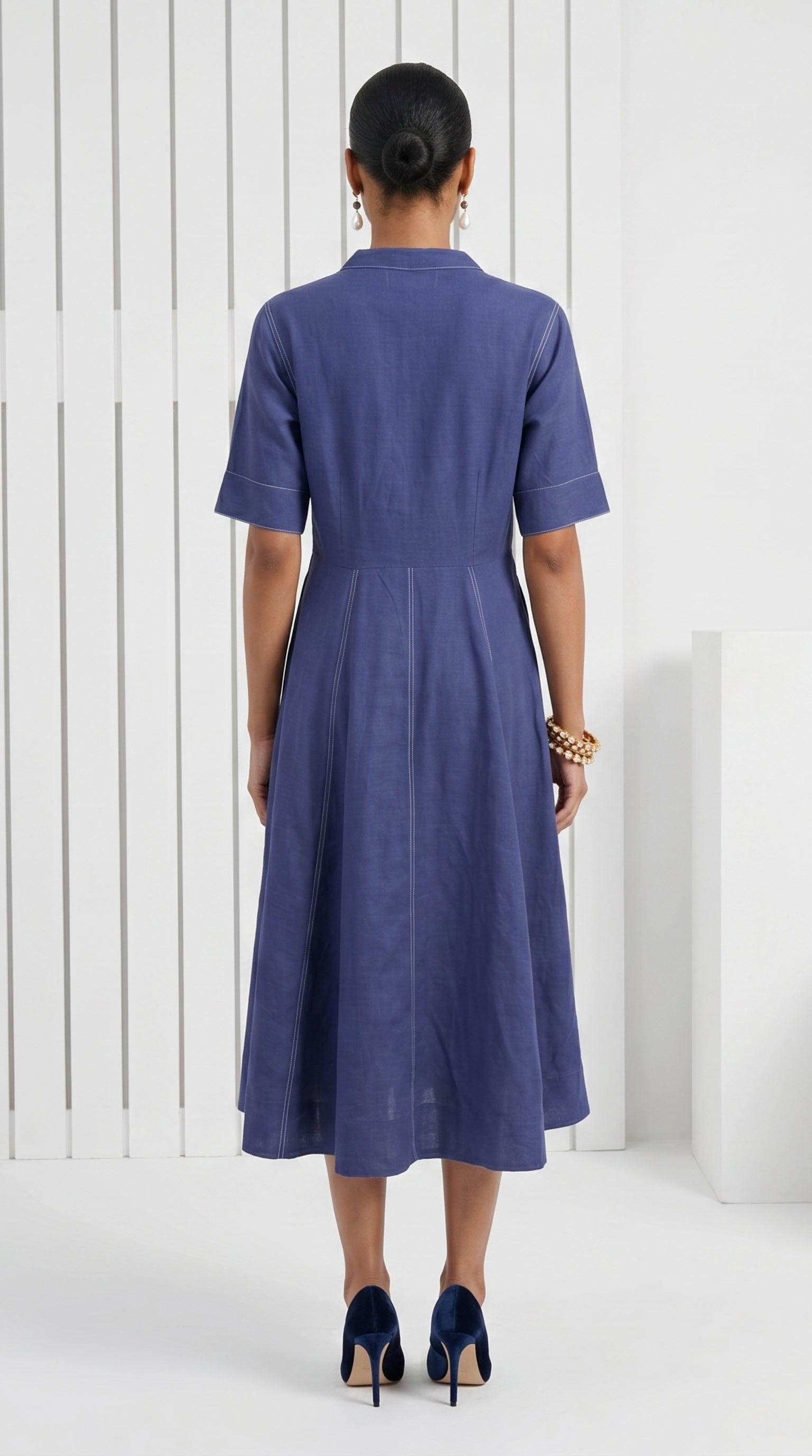 Woman wearing a blue dress standing against a white background
