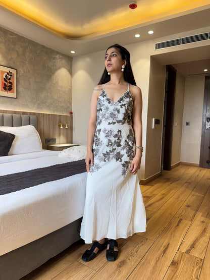 Woman in a floral dress standing in a bedroom