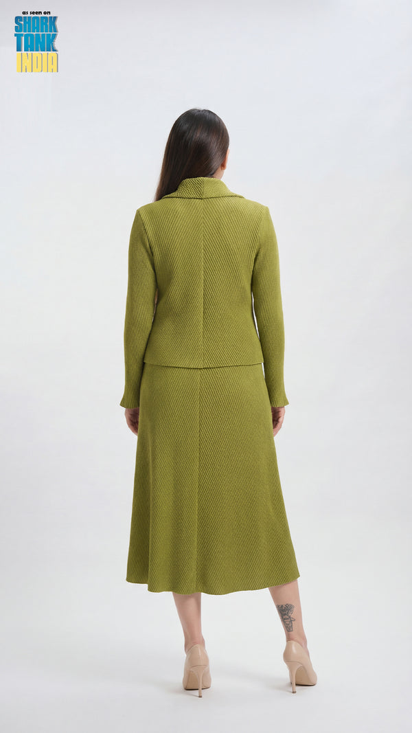 Woman wearing a green suit standing against a white background