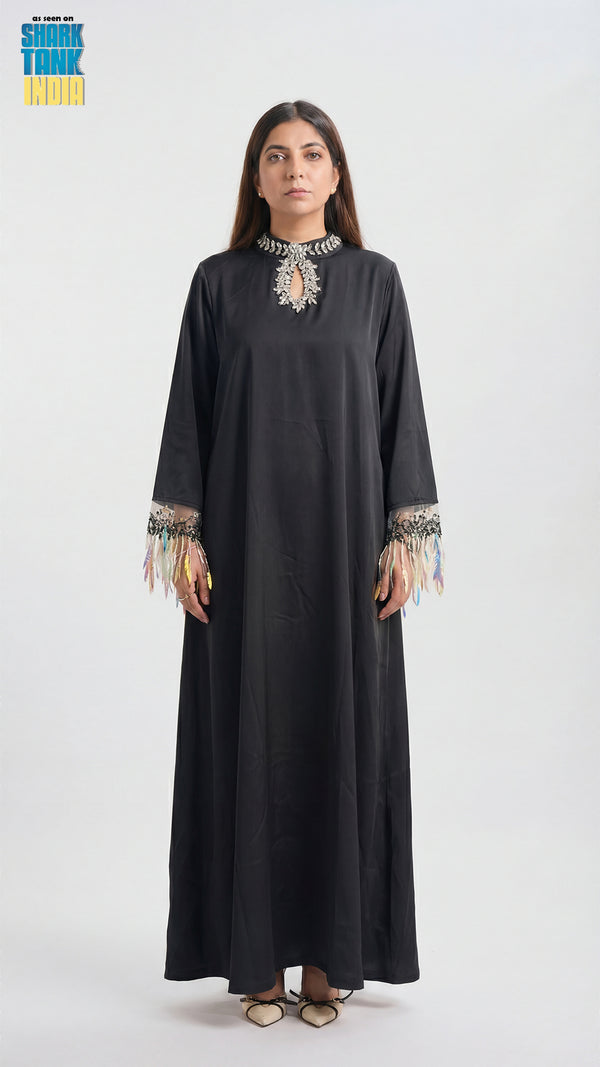 Woman wearing a black dress with embroidery on a white background