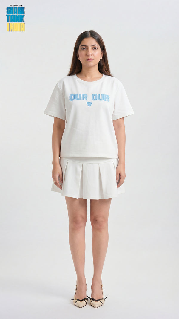 Woman wearing a white t-shirt with 'OUR' printed on it against a white background
