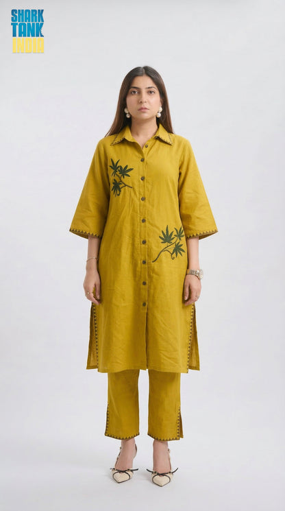 Woman wearing a mustard yellow kurta with floral embroidery on a white background