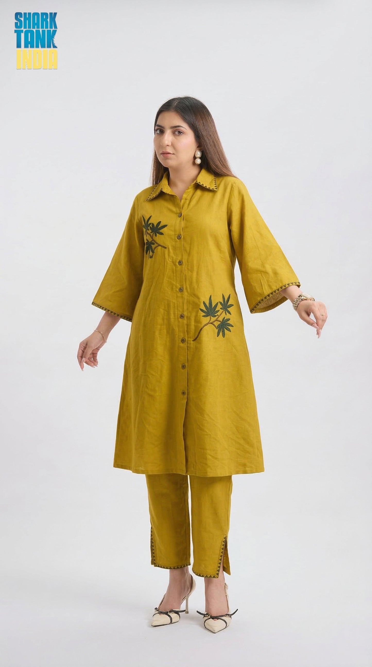 Woman wearing a mustard yellow kurta with leaf patterns on a white background