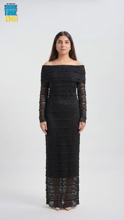 Woman wearing a black off-shoulder dress with long sleeves on a white background