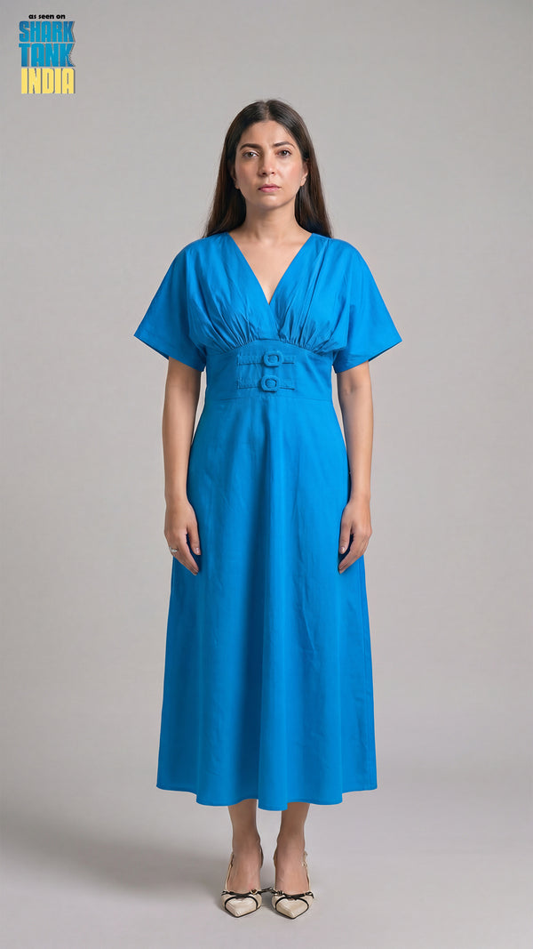 Woman wearing a blue dress against a gray background