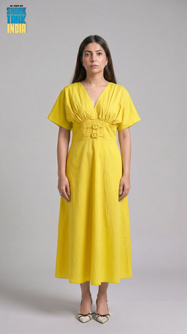 Woman wearing a yellow dress against a gray background