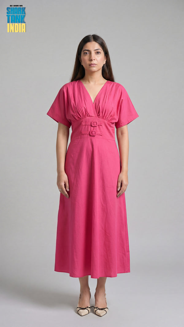 Woman wearing a pink dress against a gray background