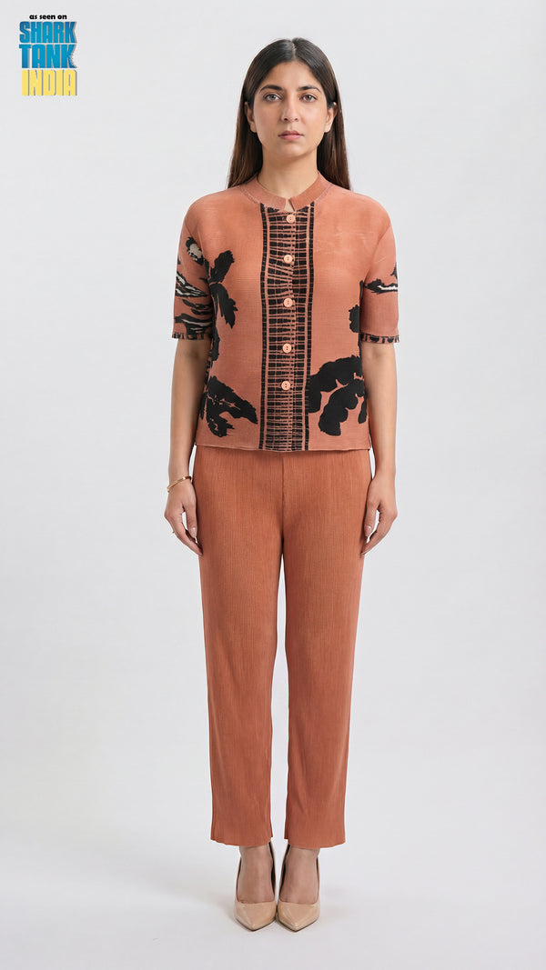 Woman wearing a brown outfit with black floral patterns on a white background