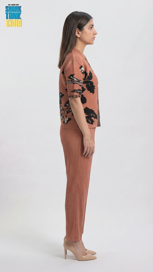 Woman wearing a pink outfit with black floral patterns on a white background