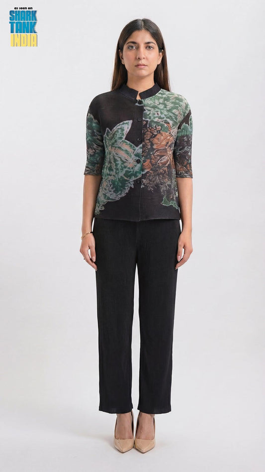 Woman wearing a black blouse with floral patterns and black pants on a white background
