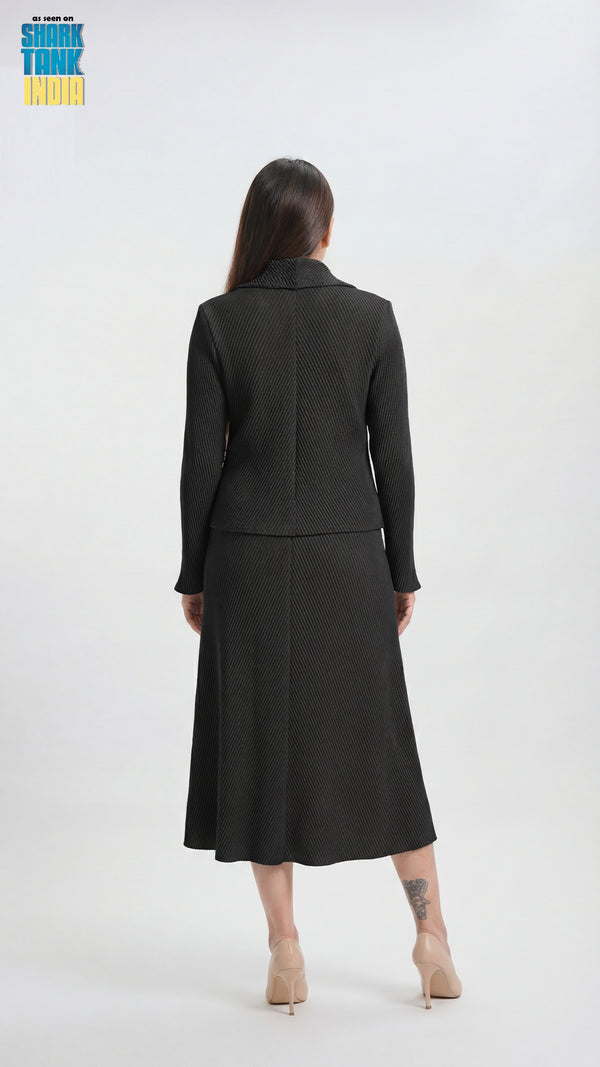 Woman wearing a black suit standing against a white background