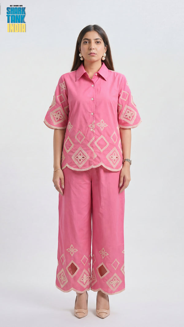 Woman wearing a pink embroidered outfit on a white background